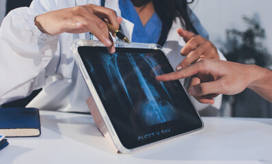 Cropped shot of an unrecognisable doctor sitting with his patient and showing her x-rays on a...