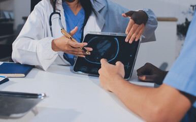 Cropped shot of an unrecognisable doctor sitting with his patient and showing her x-rays on a...