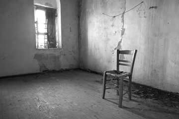 Old wooden chair in derelict room with window and wooden floor, Kardamyli, West Mani, Messenia,...