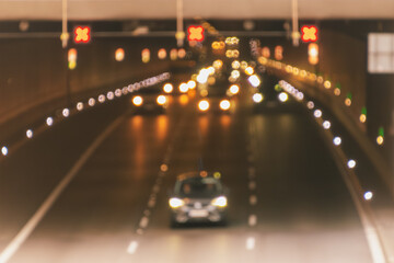 Blurry night traffic in urban tunnel with bright lights and cars