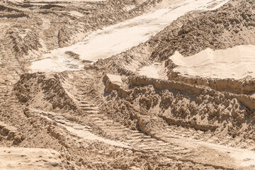 Sandy construction site with tire tracks in dry earth landscape