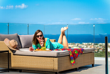 Stylish travel vibe with woman lounging on shaded daybed, enjoying luxury holiday. Scenic vacation view in elegant outdoor setting.