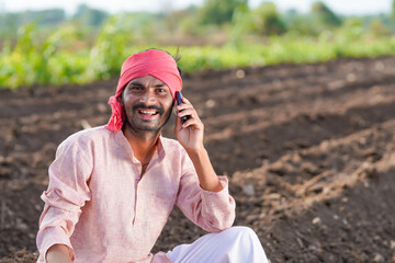 Young indian farmer talking at agriculture field