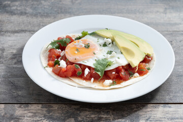 Huevos Rancheros on wooden table. Traditional Mexican breakfast.	