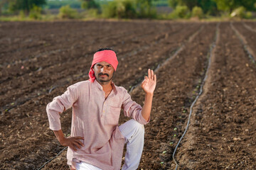 farmer sitting at agriculture field while drip irrigation complete