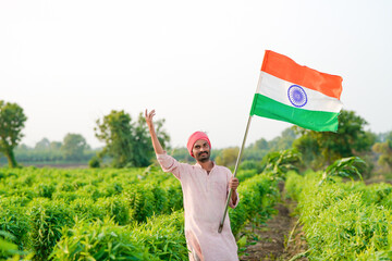 indian farmer waving national tricolor flag at agriculture field