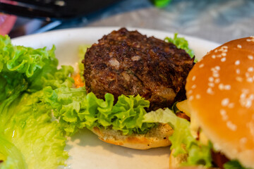 Preparing cheeseburger or hamburger with vegetables and meat. Homemade food or restaurant