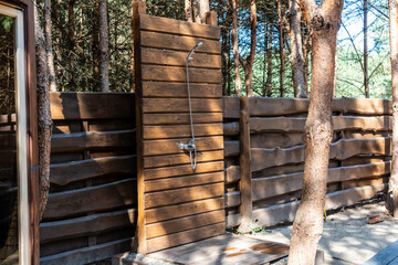 View on modern outdoor shower in forest garden. Summer shower cabin