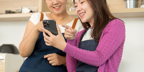Exploring Recipes: Women Engaged with Smartphone in Kitchen