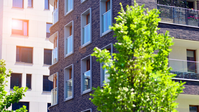 New modern block of flats in green area. complex. New modern block of flats in green area. European residential architecture harmonizing with nature. Eco-friendly living in city with greens.