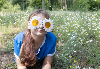 Portrait of a cute girl 11-12 years old in funny sunglasses-daisies in the park. Enjoy the moment,...