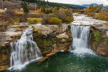 Lundbreck Falls on the Crowsnest River in autumn, with a railway bridge in the background. Alberta, Canada.