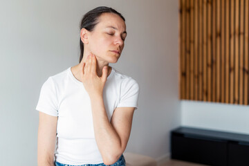 Woman struggles with chronic illness symptoms in her living room