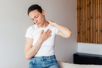 Woman experiencing discomfort due to chronic illness in her living room