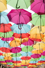 Obraz premium A vibrant array of colorful umbrellas beautifully hanging from the ceiling