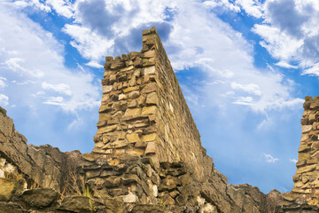 the ruined wall of the fortress, laid out of stones, stands on a hill, a fortification