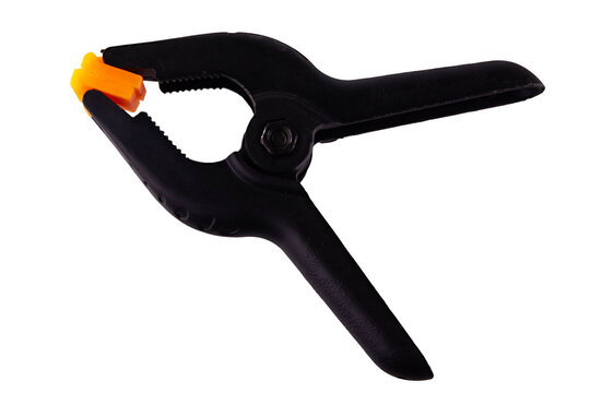 Spring clamp isolated on white background. Black plastic clamp. Clamping equipment for handicraft, joinery, photography