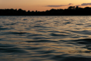 Ggentle waves rippling across a calm river surface.  Water texture is ideal for use as a natural background, meditative or peaceful ambient element. 