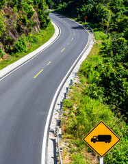 Fototapeta premium Scenic winding road cutting through lush green jungle, symbolizing adventure, journey, and challenges. Perfect for travel, transportation, or motivational content.