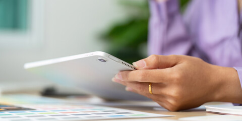 Graphic Design Focus. Designer holding tablet while reviewing color options.