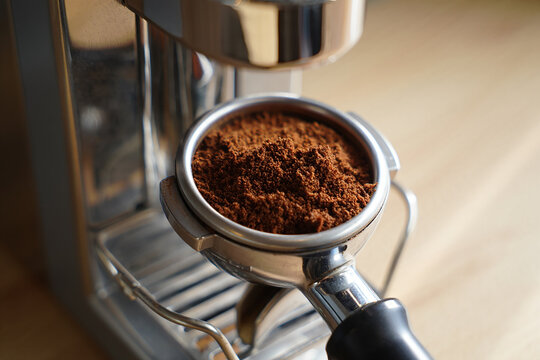 Close up of finely ground coffee beans ready for brewing in an espresso machine portafilter