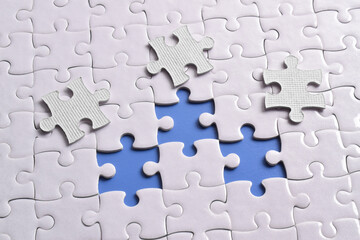 Close up white jigsaw puzzle on blue background, planning and manage to success business, smart...