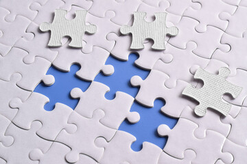 Close up white jigsaw puzzle on blue background, planning and manage to success business, smart idea and teamwork concept