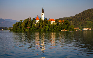 summer evening at Lake Bled - the island with the church are illuminated by the setting sun