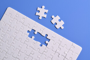 White puzzle with missing piece on blue background. Flat lay. Top view