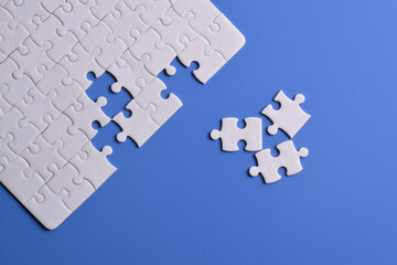 White puzzle with missing piece on blue background. Flat lay. Top view