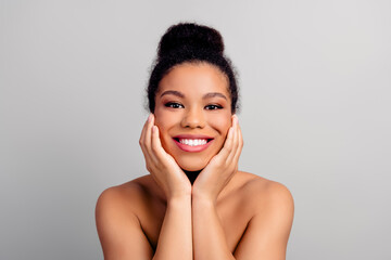 Young beautiful woman with radiant skin posing confidently against a light background, showcasing...