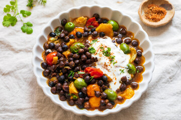 Black chickpeas stew with nocellara olives, tomatoes and orange