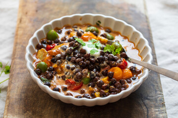 Black chickpeas stew with nocellara olives, tomatoes and orange