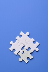 Obraz premium Four puzzle pieces on blue background. The concept of finding the right solutions in teamwork.