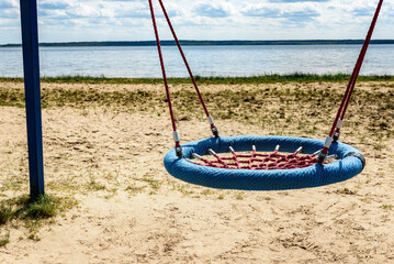 Children's swing on the sandy beach.