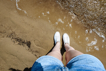 Feet on a lake sand beach on summer holidays.