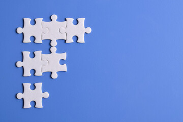 White puzzle pieces on blue background. Copy space for text, top view.