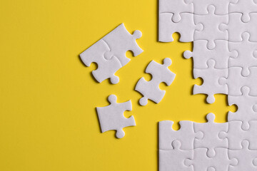 Fototapeta premium White puzzle with missing piece on yellow background. Flat lay. Top view