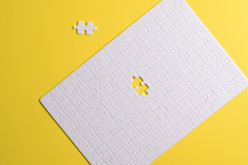 White puzzle pieces on yellow background. White square puzzle pieces grid. Business background. Copy space for text, top view.