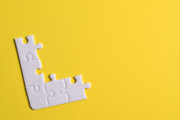 White puzzle pieces on yellow background. Copy space for text, top view.