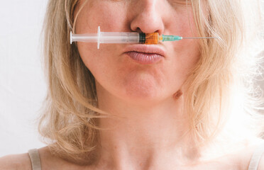Close-up of a woman's face with a syringe. Concept of beauty injections and facial care with age...
