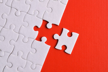 White puzzle pieces on red background. Flat lay. Top view