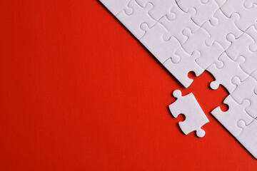 White puzzle pieces on red background. Flat lay. Top view