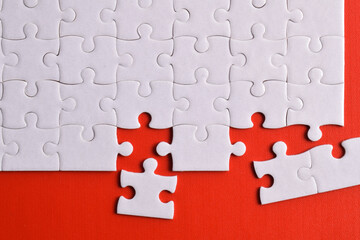 Obraz premium White puzzle with missing piece on red background. Flat lay. Top view