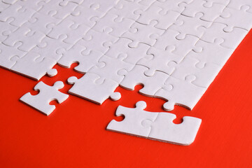 White puzzle with missing piece on red background.