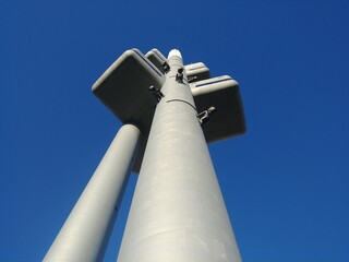 Tall pole tv tower with a blue sky in the background. There are people baby children on the pole....