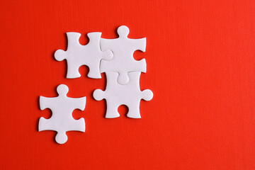 Four puzzle pieces on red background. The concept of finding the right solutions in teamwork.