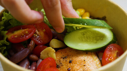 Professional chef crafting vibrant poke bowl featuring grilled salmon, fresh vegetables in...