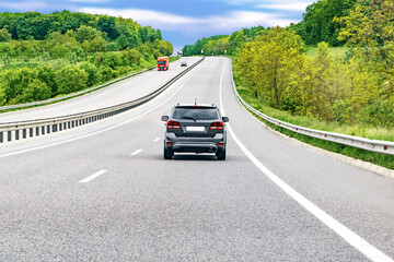 Highway mountain road goes up with cars automobiles.Scenic forest roadway nature landscape.European...