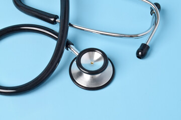 Stethoscope on light blue background, closeup. Space for text